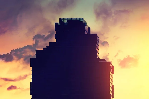 Black silhouette of a skyscraper on a background of beautiful sunset sky
