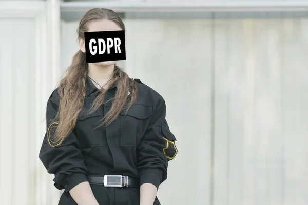 Female police officer is hiding behind the inscriptions GDPR. Data Protection Regulation. Cyber security and privacy.