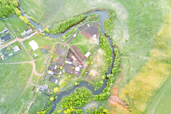 Top view of a narrow and winding river and farm houses