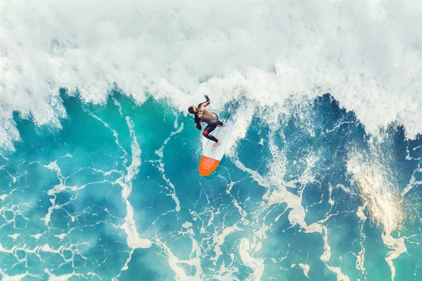 Surfer at the top of the wave in the ocean, top view