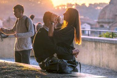 Roma, İtalya, 21 Ekim 2017: sevimli genç çift sokakta günbatımında sarılma