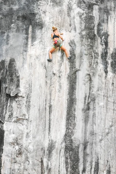 若い登山家の女性は安全装置なしで崖を登る — ストック写真