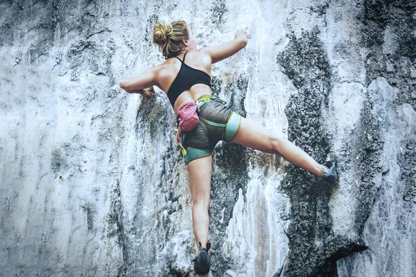 若い女性が岩に登る トーン — ストック写真