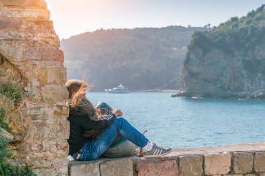 Kotor, Karadağ, 28 Nisan 2017: Taş duvarın kenarında oturan sevgi dolu çift