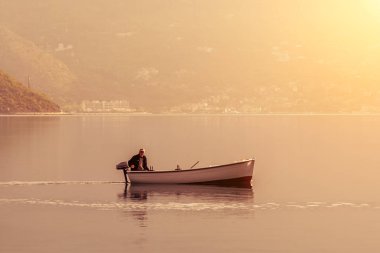 Kotor, Karadağ, 28 Nisan 2017: Gün doğumunda veya gün batımında denizde balık avlamak ta yalnız balıkçı