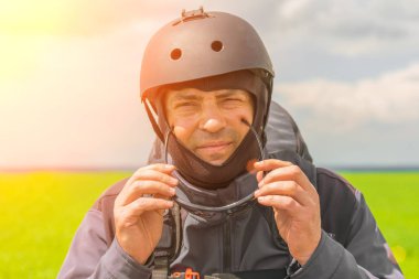 Kazan, Rusya, 16 Haziran 2017: Bir kask içinde adam yamaçparaşütü Güneş üzerinde uçan önce koruyucu gözlük koyar