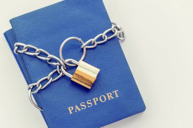 Beyaz zemin üzerinde altın bir kilidi ile zincir sarılı mavi pasaport