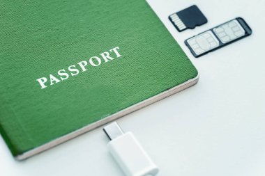 Yeşil pasaport SIM kartı, hafıza kartı ve usb kablo beyaz bir arka plan üzerinde