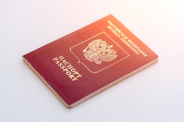 Güneş ışığı altında beyaz zemin üzerine kırmızı Rus pasaportu
