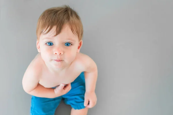 Blonde Baby Boy Blue Eyes Blue Shorts Sitting Gray Background — Stock Photo, Image