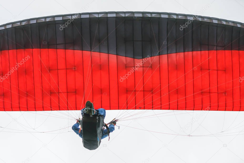 Red and black paraglider in the sky