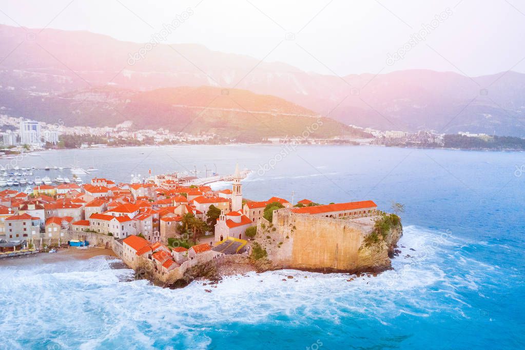 Ancient European city with a church near the sea in the sunlight, top view
