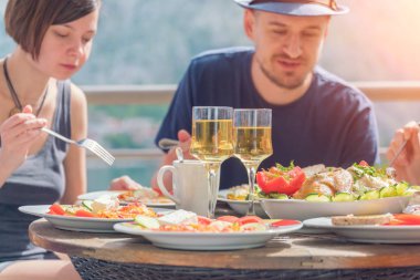 Gün ışığında terasta akşam yemeği yemek bir grup insan