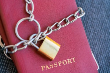 Kırmızı pasaport mavi Tekstil zemin üzerine altın bir kilidi ile zincir sarılı yakın çekim