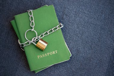 Yeşil pasaport mavi Tekstil zemin üzerine altın bir kilidi ile zincir sarılı