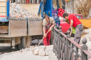 Kotor, Karadağ, 28 Nisan 2017: Erkekler kürek ile inşaat çöp bir kamyona yüklemek