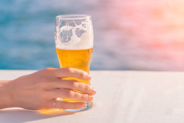 Bardak bira havuzun kenarında bir kadının elinde