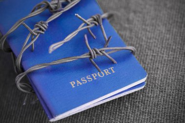 Arkasında dikenli tel bir gri Tekstil zemin üzerine mavi pasaport yakın çekim