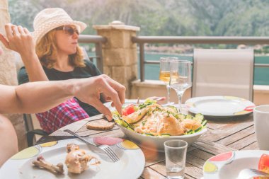 İnsanlar terasta şarap yiyip içiyor.