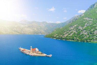 Bakire ada güneş ışığı altında kayalıkta yukarıdan