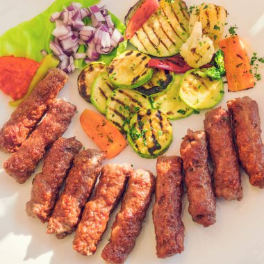 Kavrulmuş et, kabak, biber ve soğan bir beyaz tabak, üstten görünüm, yakın çekim ızgara üzerinde iştah açıcı parçaları