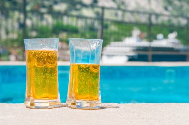 İki bardak havuzun kenarında bira ile