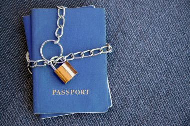 Mavi pasaport mavi Tekstil zemin üzerine altın bir kilidi ile zincir sarılı yakın çekim