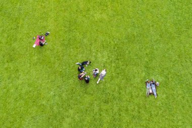 Parkta yeşil çim üzerinde grup insan üstten görünüm