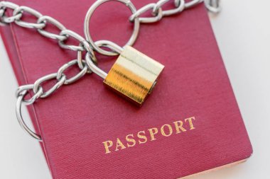 Beyaz zemin üzerinde altın bir kilidi ile zincir sarılı kırmızı pasaport