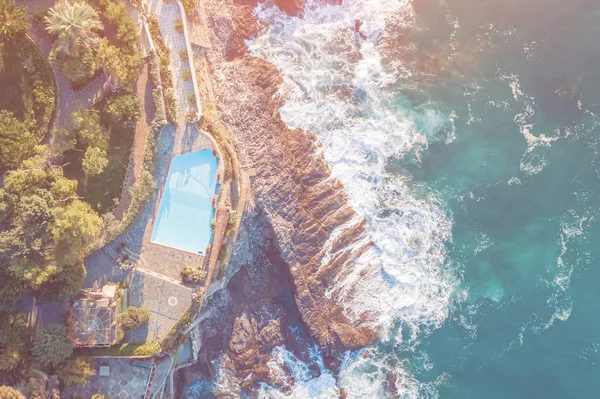 Top view of a pool on a rock by the sea in the sunlight