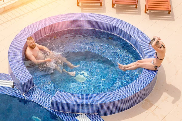 Woman and man in a round pool