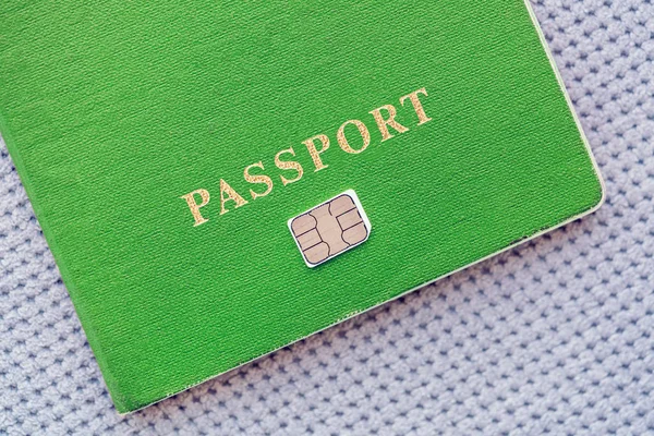 Green Passport with sim card  on a gray textile background