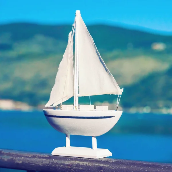 Λευκό Μικρό Ενθύμιο Sailboat Παιχνιδιών Ενάντια Στη Θάλασσα — Φωτογραφία Αρχείου