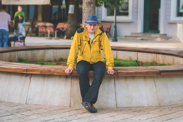 도시의 벤치에 노란색 재킷과 모자에 — 스톡 사진