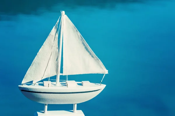 Λευκό Μικρό Ενθύμιο Sailboat Παιχνιδιών Ενάντια Στη Θάλασσα — Φωτογραφία Αρχείου