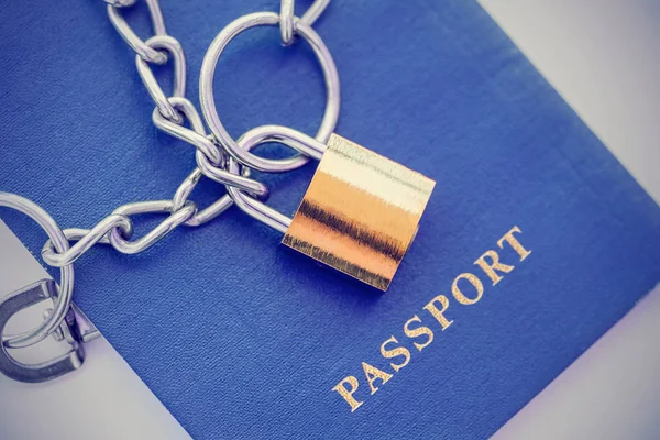 Der blaue Reisepass ist in eine Kette mit goldenem Schloss gehüllt. gemildert — Stockbild Der Blaue Reisepass Ist Eine Kette Mit Goldenem Schloss Gehüllt — Stockfoto