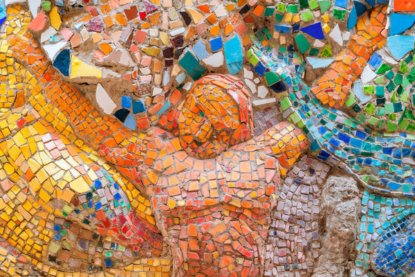 Деталь красивой абстрактной керамической мозаики с изображением разноцветных людей
