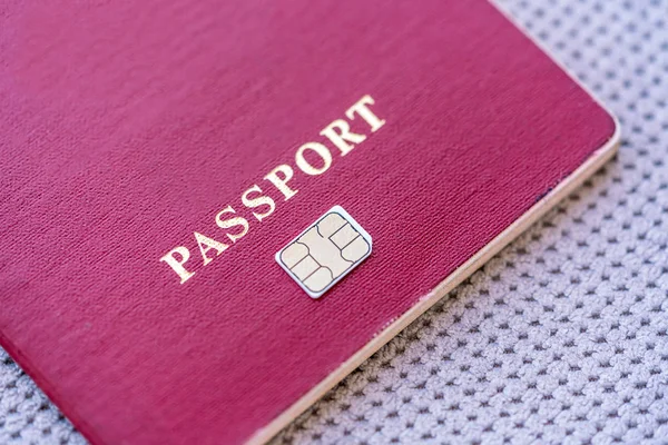 Red Passport with sim card  on a gray textile background