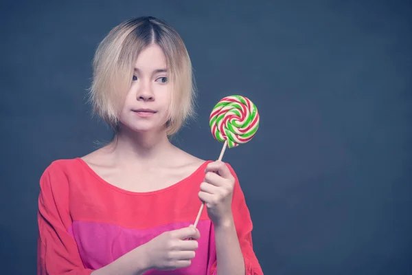 Blond Meisje Een Rode Blouse Kijken Naar Lollipop Tiener — Stockfoto