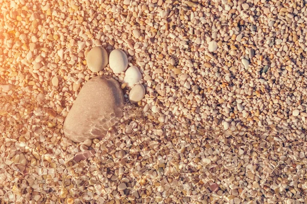 太陽の光のビーチで石で作られた足跡 — ストック写真