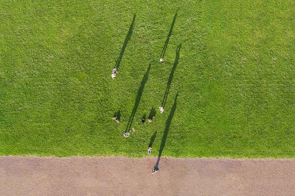 Top view of people on a green lawn near a road