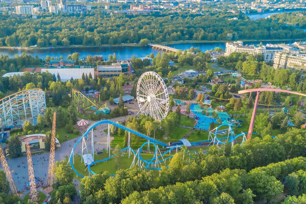Aerial view of the amusement park with a ferris wheel and roller coaster