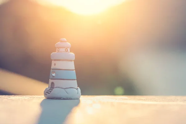 Small souvenir toy lighthouse  at sunset