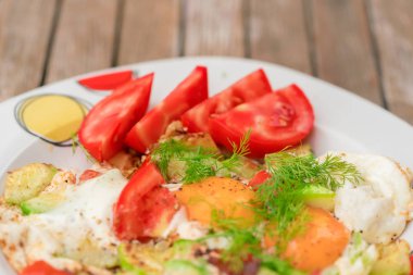 Kızarmış yumurta domates ve dereotu bir plaka üzerinde yakın çekim