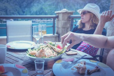 İnsanlar yeme ve terasta şarap içme. Tonda