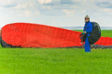 Kazan, Rusya, 16 Haziran 2017: İniş sonra yeşil bir alan üzerinde kırmızı bir yamaçparaşütü adamla