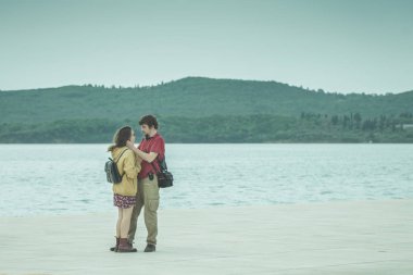 Kotor, Karadağ, 28 Nisan 2017: Genç adam ve kadın denizde kucaklaşma. Tonda