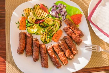 İştah açıcı adet kavrulmuş et, kabak ızgara, biber ve soğan Beyaz tabakta üstten görünüm