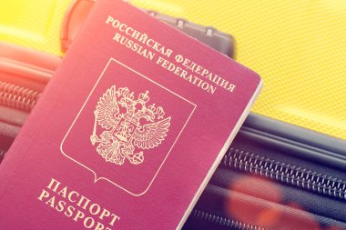 Güneş ışığı altında sarı bir bavul Rus pasaportla. Tonda