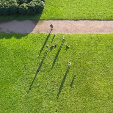İnsanlar rahatlatıcı bir yeşil çim, üstten görünüm üzerinde bir parkta